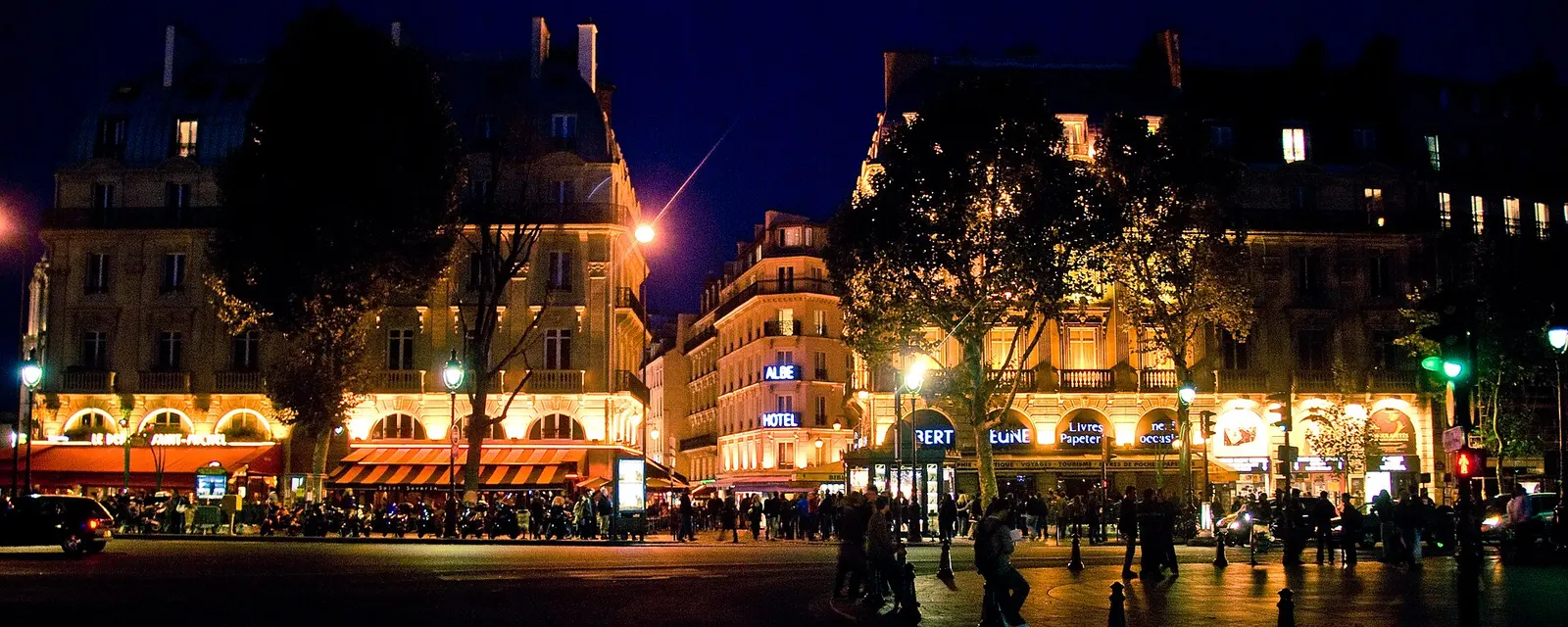 A Latin Quarter street at night with cafe terraces
